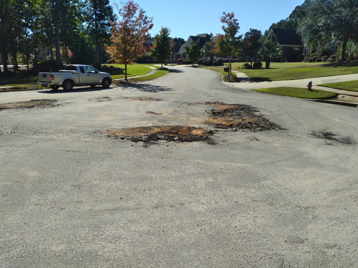 Image of road with pot holes filled in